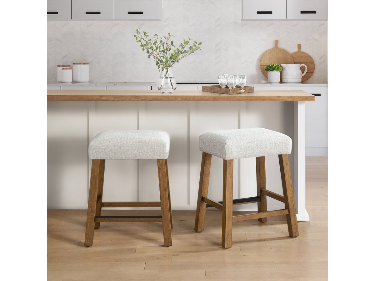 Two Benny counter stools with walnut-finished wood bases and light-gray upholstered seats