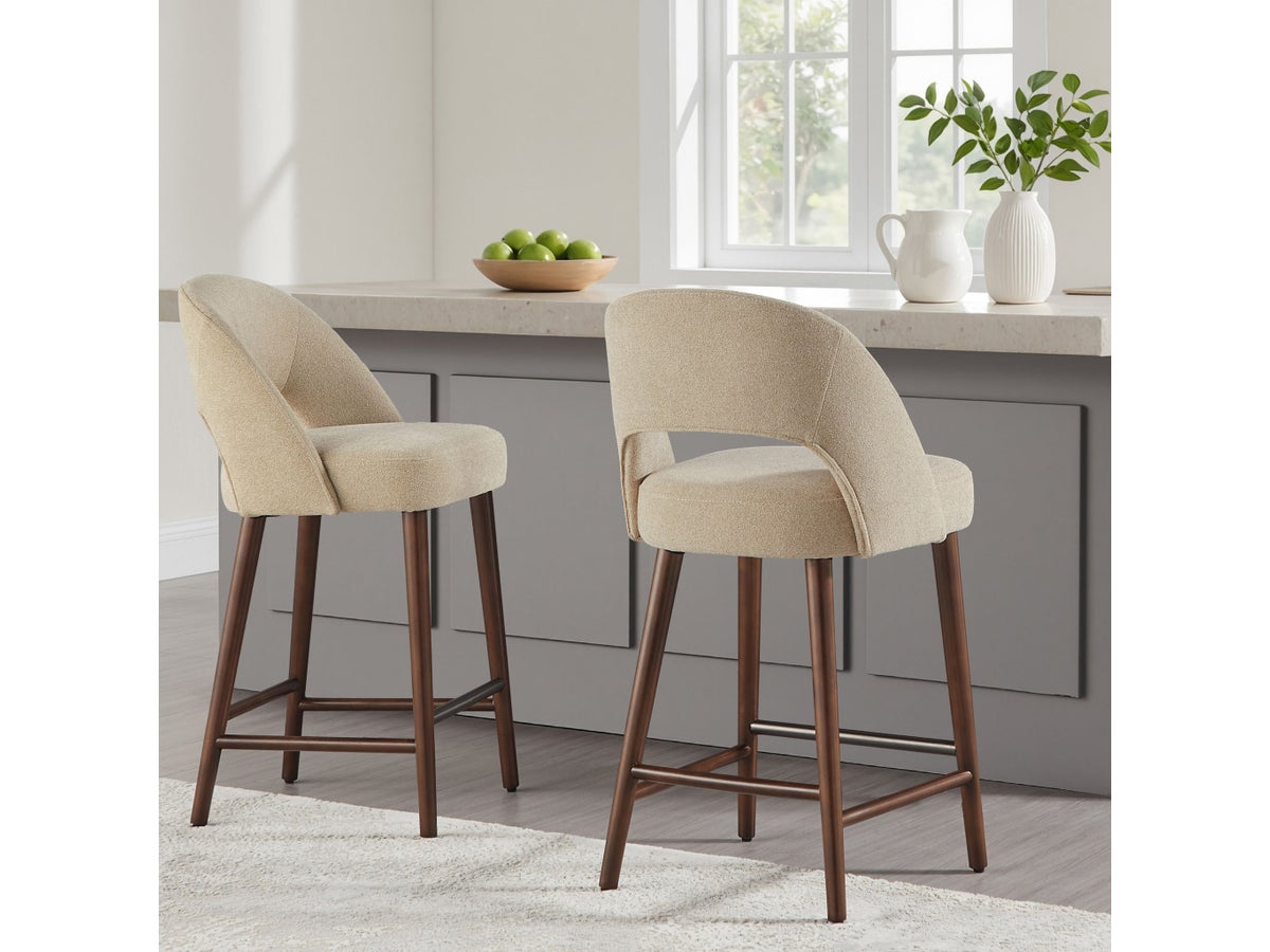 Two Lilah counter stools with walnut-finished bases and curved tan upholstered backs